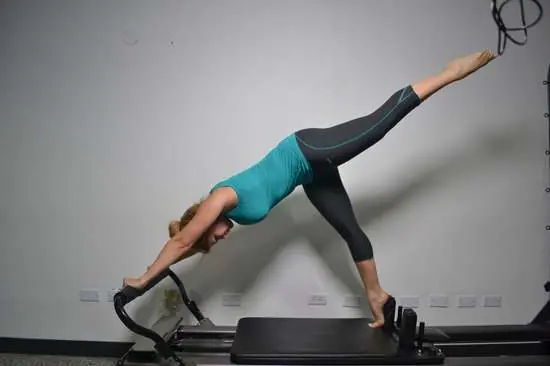 Ejercicio de estiramiento en Pilates Reformer, Ayre Pilates